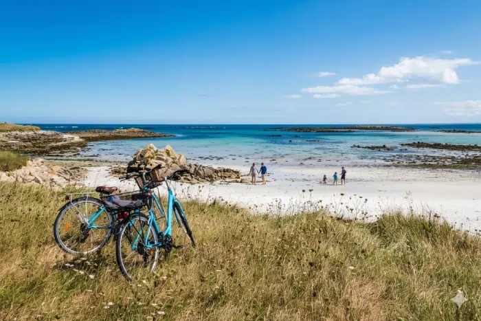 Deux vélos posés face à une plage sauvage près de Bénodet, cadre idéal pour une balade depuis un camping Bénodet entre nature et océan.