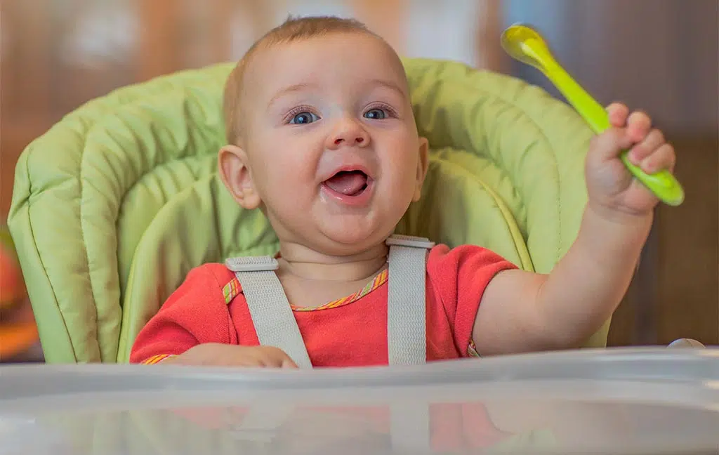 Bébé assis dans une chaise haute illustrant les équipements bébé disponibles dans les mobil-homes à Concarneau