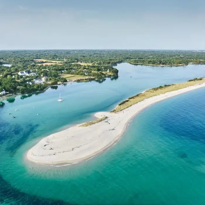 Petite crique aux eaux turquoise près du Camping Fouesnant, avec sable fin et familles profitant de la plage